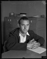 Jay Thomas sits at a desk, Los Angeles, 1934