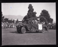 Carrie Jacobs Bond and others riding in a decorated automobile at the Tournament of Roses parade, Pasadena, 1927