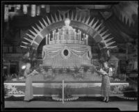 Two women stand in front of the Sunkist display at the National Orange Show, San Bernardino, 1933