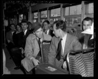 Actor Jimmy Stewart's induction in United States Army; Stewart talking to fellow Army inductees on Red Car train, 1941