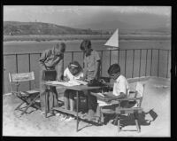 Jim Sherry, Joan Sherry, John David, and Tony Brackett working on their newspaper, Newport Beach, 1935J