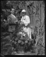 Horticulturist Harry L. Bateson, Mrs. Queen Boardman, and zinnia named for Queen Boardman, Los Angeles, 1933