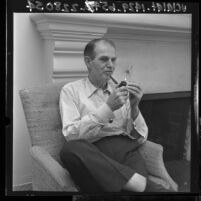 Alger Hiss seated and smoking a pipe, 1965