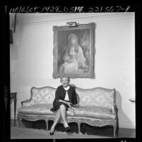 Actress Mary Pickford seated under a portrait of herself at the Pickfair Estate in Los Angeles, Calif., 1963