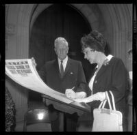 Gene Thurston assisting Fifi D'Orsay sign scrapbook at Francis X. Bushman's funeral in Los Angeles, Calif., 1966