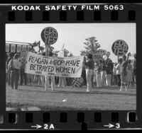 People holding "ERA YES" signs and banner reading "Reagan & GOP Have Betrayed Women" at equal rights amendment rally in Los Angeles, Calif., 1981