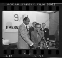 Los Angeles Mayor Tom Bradley and Councilman Marvin Braude flipping "on switch" for 911 emergency telephone system, 1984