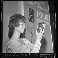 Julie Wright examining a Hewlett Packard HP35 pocket calculator at Wescon convention in Los Angeles, Calif., 1972