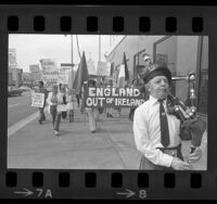 Bagpiper leading demonstrators with banner reading "England out of Ireland" to British Consulate in Los Angeles, 1974