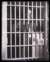 Reverend Robert Shuler with hands on hips, standing in jail cell, Los Angeles, 1930