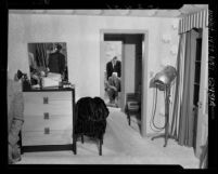 Two Los Angeles police detectives looking over the body of actress Carole Landis in Landis' home in Los Angeles, Calif., 1948