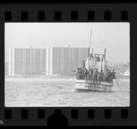 Men fishing off the boat, Kia Ra, with beach and condominiums in background at Santa Monica, Calif., 1976