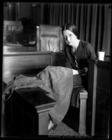 Eunice Pringle on the witness stand examining a dress during Alexander Pantages rape trial