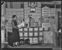 Elsie Bell stands before a display on the Times Bible Game, Los Angeles, 1934