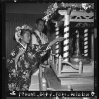 Larie Akashi pours sweat tea over Kanbutsu statue at a Hanamido ritual in Los Angeles, Calif