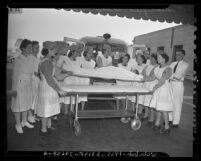 Women's Ambulance and Defense Corps. unloading patient from ambulance in Lincoln Heights, Calif., 1943