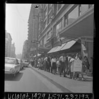 Protest march down sidewalk, sign reading "NAPP For Community Action" in downtown Los Angeles, Calif., 1966