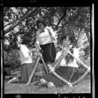 Three Crescenta Valley Camp Fire Girls constructing chairs out of tree limbs in Glendale, Calif., 1964