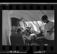 Flight attendants and businessmen in a conference room built into a Boeing 747, Calif., 1970