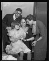 Virginia Carter sits on her mother’s lap with their lawyers Anna Zacseck and Ed Haumsech standing next to them, Los Angeles, 1935