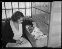 Los Angeles County Jail matron Vada Sullivan with baby sleeping in dresser drawer, 1933