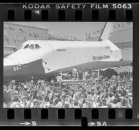 President Ronald Reagan on podium next to the space shuttle Enterprise as crowd cheers at Edwards Air Force Base, Calif., 1982