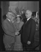 Ernest R. Utley is welcomed into the office of the Bankruptcy Court by Judge William P. James as wife Laura Utley watches, Los Angeles, 1936