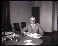 Los Angeles police detective Charles Reimer sits at a desk filling out paperwork Los Angeles, 1926