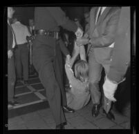 Protester Sylvia Barkley removed forcibly from City Council chambers after being denied a hearing regarding police actions at a demonstration during President Johnson's visit to Century Plaza Hotel. A. 1967