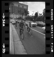 Councilman Marvin Braude bicycling to work with Claire Rogger, and Bob Reiter, passing the Sheraton West building in Los Angeles, Calif., 1974