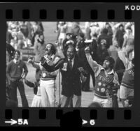 Los Angeles Mayor Tom Bradley cheering with UCLA Bruins cheerleaders during game against USC, 1973