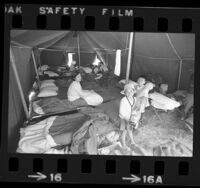 Vietnamese mother and children in tent at refugee camp at Camp Pendleton, Calif., 1975