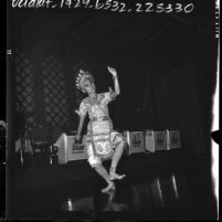 Thai American dancer wearing silver beaded costume practicing for festival in honor of Thai queen's birthday, Los Angeles, Calif., 1964