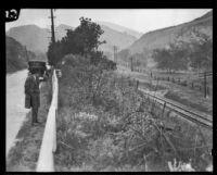 Man inspects the location where the body of Dr. Benjamin Baldwin was found, Newhall, 1924