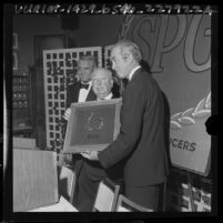 Director Alfred Hitchcock receiving Producers Guild award from actors James Stewart and Cary Grant, 1965