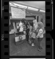 Neil Zevnik manning a kissing booth for George McGovern fundraiser in Los Angeles, Calif., 1972