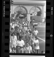 Participants passing gates of Paramount Studio during walk for AIDS Project Los Angeles, 1987