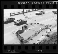 Automobiles driving around buckled pavement on Pacific Coast Highway near Las Tunas Beach, Calif., 1980