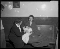 Young woman with baby, flood victims, receiving aid seated on bench, La Crescenta-Montrose, 1934