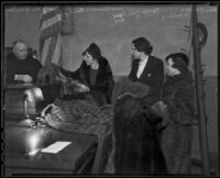 Barbara Woodling, Terrys Gambord, and Mrs. Alemeda Finley display furs before Judge William R. McKay in courtroom, Los Angeles, 1936