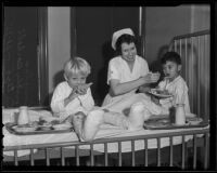 Nurse Dorothy Barkell helps Gordon Douglas and Rupert Oriego with Thanksgiving dinner at General Hospital, Los Angeles, 1935