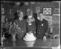 Fire chief Ralph Scott, Mrs. Adeline Scott, and O. [?] Edwards, with flowers and cake, 1929