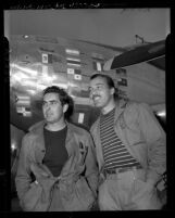 Actors Tyrone Power and Cesar Romero beside Power's plane on return from Latin-American good-will tour, Los Angeles, 1946