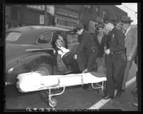 Los Angeles police remove Felipe Rojas from police car to ambulance stretcher after shooting spree in Chinese produce company, 1949