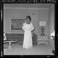 Actress Ann-Margret in livingroom, modeling gown she will wear to Lyndon Johnson's Inaugural Ball, 1965