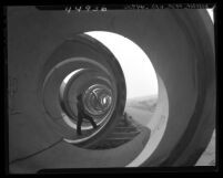 Worker standing inside section of 12-foot pipe of sewer line in Los Angeles, Calif., 1947