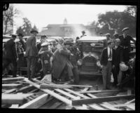 A wounded child and man are carried from a collapsed grandstand at the Tournament of Roses Parade, Pasadena, 1926