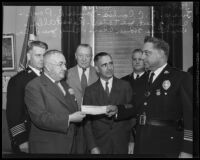 R. C. Combes, James R. Page, Joe Taylor, Robert Allen, Homer Cross, and Chief James E. Davis with the cashier's check for the Community Chest campaign, Los Angeles, 1935