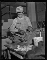 Goodwill worker repairs a child's wagon, Los Angeles, 1938