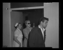 Barbara Payton leaves Franchot Tone’s hospital room, following Jerry Bialac, a mutual friend, 1951